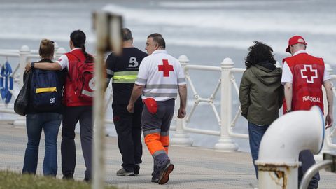 El padre (2d) y la madre (i) del desaparecido reciben apoyo emocional mientras miembros del operativo de b�squeda y rescate peinan este martes la zona donde desapareci� el joven de 19 a�os desaparecido ayer, lunes, cuando se ba�aba en la playa de Salinas
