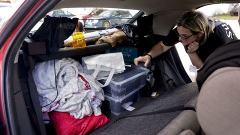 Isabel Otero, coloca el maletero, donde guardan la ropa de cama con la que duermen en su coche.