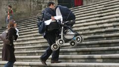 Una pareja sube en brazos el carrito de un beb� por unas escaleras en Santiago