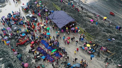 Amigos y familiares se reúnen cerca de los cuerpos de los fallecidos en el derrumbe de una mina de jade en Birmania