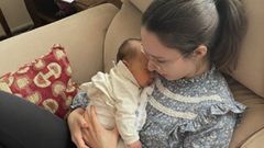 Mar�a estudiando con su beb� en brazos.