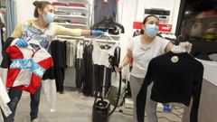 Imagen de archivo en la que dos trabajadoras desinfectan prendas en una tienda de Vilagarc�a