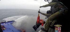 Una mujer es izada a un helic�ptero de salvamento desde el ferri �Norman Atlantic� todav�a en llamas mientras los remolcadores disparan agua a presi�n. 