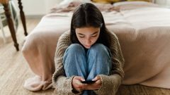 Una joven observa ensimisma su telfono mvil.