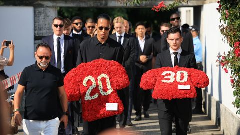 Los jugadores del Liverpool Virgil van Dijk y Andrew Robertson, portando sendas ofrendas florares como homenaje a Diogo Jota y su hermano André Silva