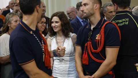 La presidenta de la Comunidad de Madrid, Isabel D�az Ayuso, entre dos bomberos.