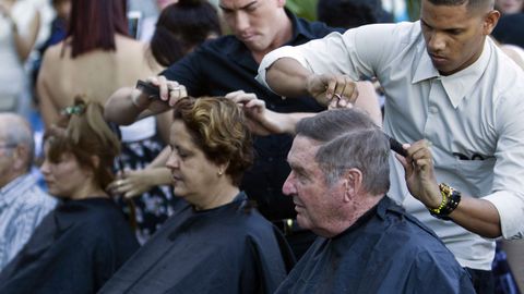 Varios peluqueros cortando el pelo