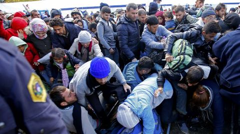 Un grupo de refugiados tratan de romper un cordn policial en  Sentilj, en la frontera de Eslovenia con Austria