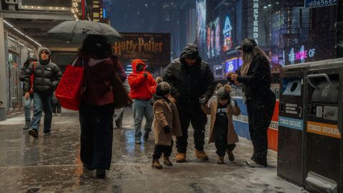 Una familia pasea por Times Square, en Nueva York, cubierta de nieve