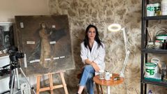 La restauradora asturiana Laura Aylagas, junto con una de las obras que ha restaurado en el nuevo taller que tiene en Siero