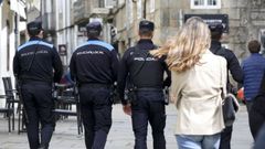 En una imagen de archivo, agentes de la Policía Nacional y de la Local patrullan conjuntamente por Santiago para vigilar el cumplimiento de las medidas decretadas para frenar la pandemia del coronavirus