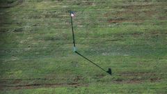 Una bandera estadounidense en medio de las fosas comunes de miles de enterrados, en Hart Island. 