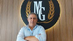 Miguel Giz, de 58 a�os, junto al logotipo de la marca que lleva sus iniciales, en la cafeter�a-pasteler�a que gestiona en Ortigueira, el antiguo Dolan