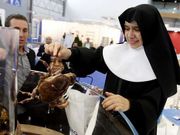 Una monja recoge una n�cora donada por un expositor.