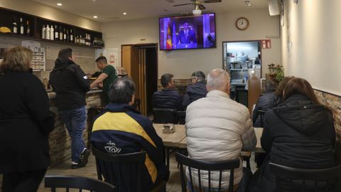 Clientes de un bar de Santiago atienden a la comparecencia de Pedro Snchez.