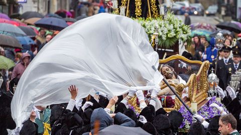 La imagen del Santo Cristo Yacente es cubierta con un plástico ante la lluvia que apareció y acortó el recorrido de la procesión del Santo Entierro, de la cofradia del Santo Entierro y Nuestra Señora de los Dolores, que se celebra hoy Viernes Santo en Oviedo dentro de los actos de la semana santa ovetense.