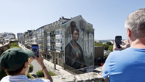 Turistas fotograf�an un mural cercano a la muralla de Lugo.