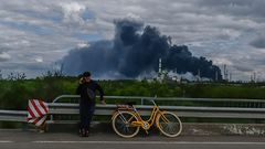 Un hombre habla por tel�fono, mientras la refiner�a de petr�leo de Lysychansk, ciudad vecina de Severodonetsk, arde al fondo.  