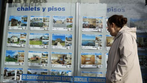 Una mujer delante del escaparate de una inmobiliaria en A Coru�a