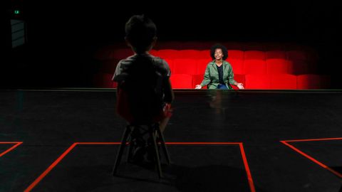 Un niño se sienta en el escenario durante una representación teatral en París, donde las salas han empezado a reabrir