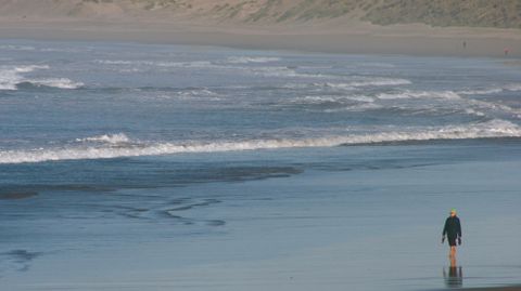 Un grupo de personas pasea por una playa del centro de Asturias.Un grupo de personas pasea por una playa del centro de Asturias