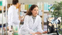 Una profesional sanitaria, consultando el ordenador en una farmacia, en una imagen de archivo.