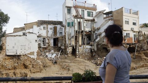 Una mujer observa varias casas daadas en Chiva 