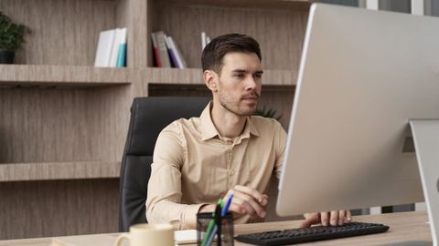 Una persona escribiendo con un ordenador.