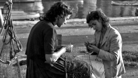 Teresa Lengomín y Elvira Goyal afeitando un trasmallo en el muelle de la Llera, en Luarca (1948). Camilo Gómez