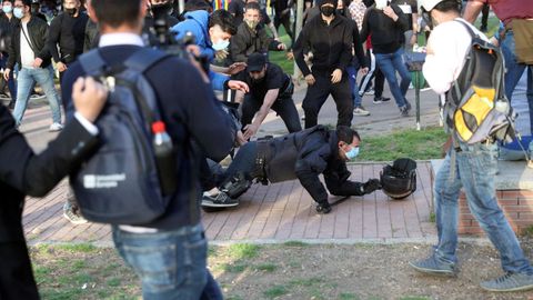 Un polica nacional por los suelos durante las cargas que se han registrado en protesta por el acto de precampaa de Vox