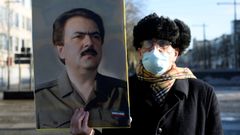 Un hombre sostiene un retrato del l�de rde  los Muyahidines del Pueblo en el exterior del tribunal de Amberes.