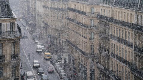 Gente caminando por la calle bajo los copos de nieve en Pars (Francia).