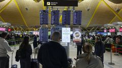 Pasajeros consultando el estado de sus vuelos en un aeropuerto.