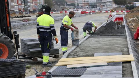 Operarios componiendo una de las aceras en O Bertn el pasado viernes.