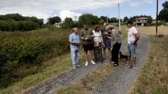 Un grupo de vecinos, junto a una de las fincas que piden que se limpie y que tiene una parte de maleza y otra de arboleda.