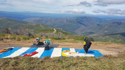 Preparativos de varios parapentistas para iniciar los vuelos