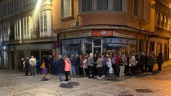 Cola nocturna ante la agencia de viajes de la calle de la Tierra, que doblaba por la calle María.