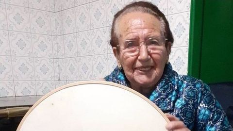 Mara Barreiro, ms conocida como Mara de Andrs, es una vecina de 99 aos de Penelas (Teo) muy querida en su aldea y nacida en Boimorto. Hija de Andrs O Zoqueiro, trabaj durante dcadas en el oficio paterno rompiendo estereotipos de gnero y es una fuente de saber en cuanto a leyendas, ritos, cantos de foliada y hasta recetas tradicionales. En la foto, con un curioso instrumento ideado por su padre, llamado bruador.