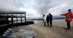 Las mariscadoras se�alan c�mo el agua se filtra entre las tablas del canal del regato de A Concha, da�adas por el temporal.