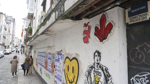 Pared deteriorada en un bajo de la calle de la Tierra donde hay varios grafitos