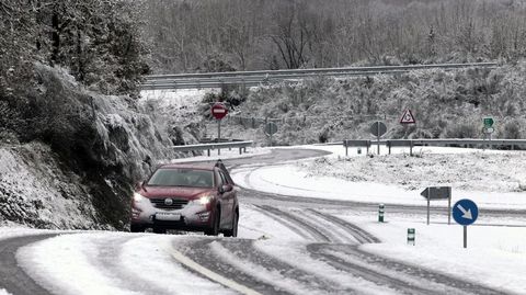 Un coche, en una carretera nevada el invierno pasado en O Incio, uno de los municipios en los que se encuentran los silos de sal del dispositivo de la Diputacin