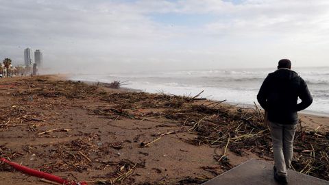 Una persona pasea este jueves por la playa de la Barceloneta, uno de los lugares ms gravemente afectados por la borrasca Gloria