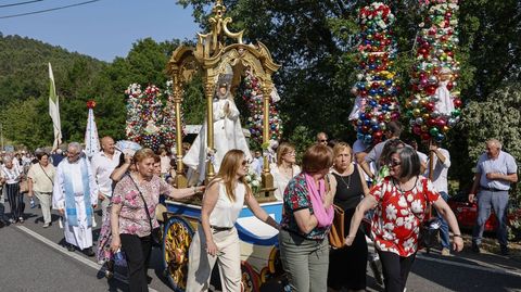 Estandartes y ramos con bolas de colores acompañan a la virgen en la procesión.