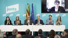 Los exconsellers Llu�s Puig (3i) y Toni Com�n (2d), junto al secretario general de Junts, Jordi Turull (3d), la secretaria de organizaci�n Judith Toronjo (d), las vicepresidentas M�nica Sales (i) y Miriam Nogueras (2i), y el presidente del partido, Carles Puigdemont (en la pantalla), durante la reuni�n de la ejecutiva de Junts celebrada este lunes, tras volver a Espa�a despu�s de serle aplicada la ley de amnist�a.