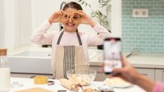 Una mujer hace una foto de su hija haciendo galletas, en una imagen de archivo.