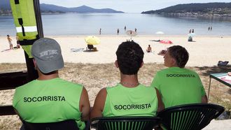 Tres socorristas vigilando este viernes la playa de Bro�a, en Outes, en el primer d�a de servicio de esta temporada