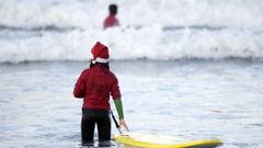 Haciendo surf en la playa de Patos con vestimenta de Pap Noel
