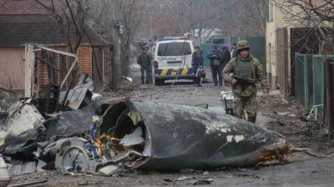 Un soldado camina entre los restos de un avin derribado esta madrugada en Kiev