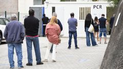 Personas haciendo cola en el punto covid del Hospital Provincial de Pontevedra para hacerse una PCR. 