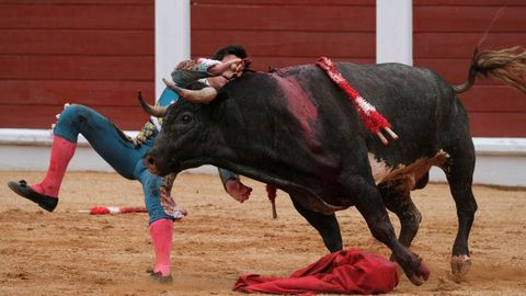 �lvaro Lorenzo sufre un revolc�n durante la faena a su primer toro durante el festejo de la feria taurina de Bego�a,